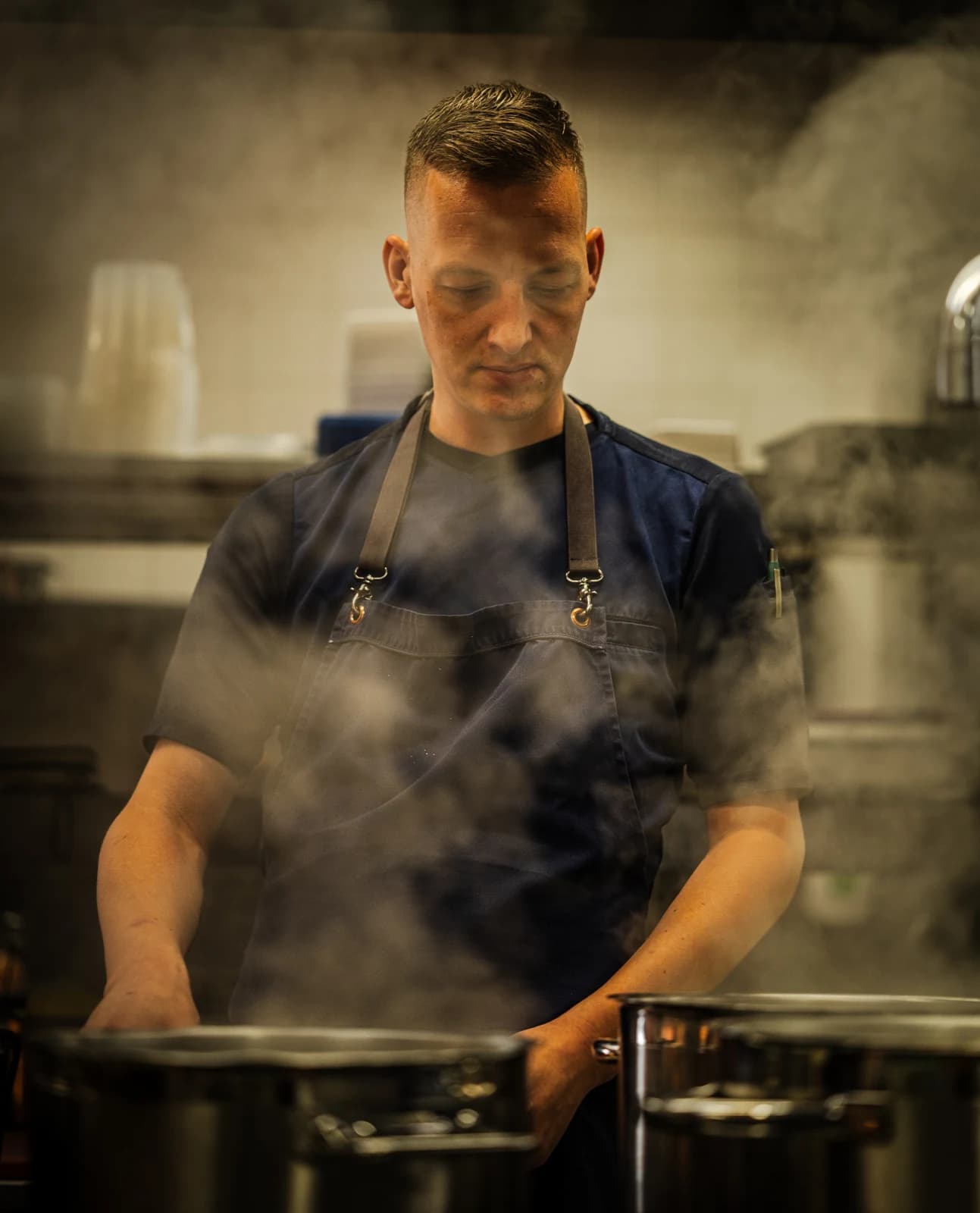 Een chef werkt tussen opstijgende stoom in de keuken van Landgoed Groenendaal in Heemstede, in de regio Haarlem.